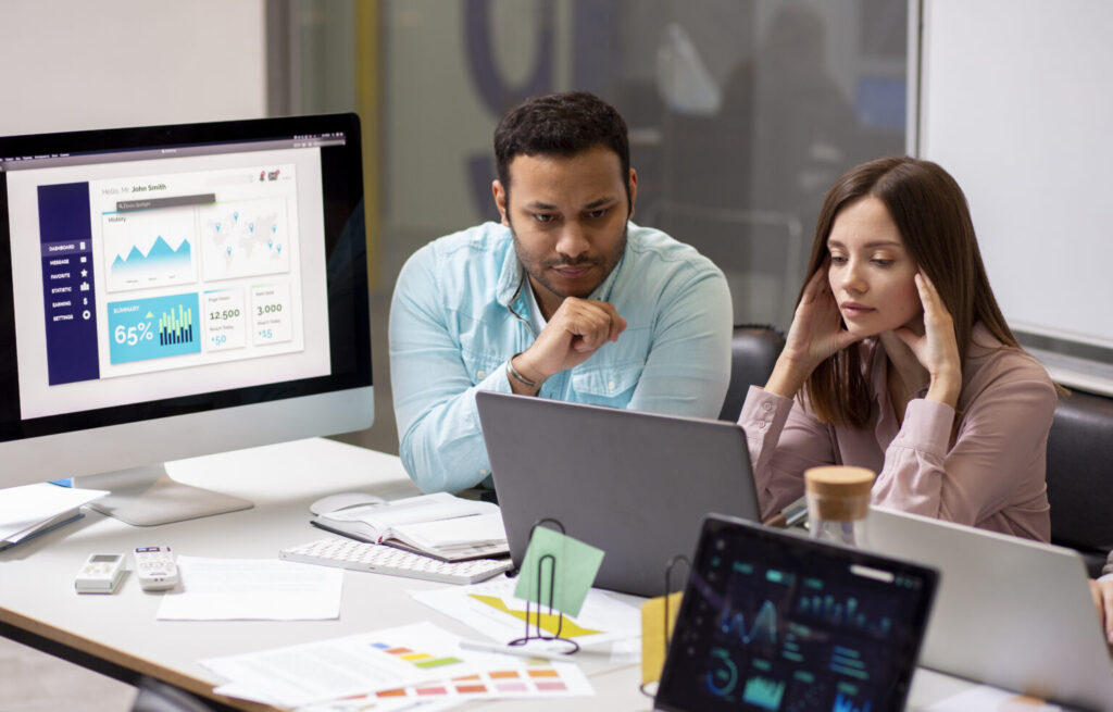A diverse team of AWS infrastructure experts reviewing a scalable cloud architecture diagram on a large screen, with AWS service icons and upward growth arrows.