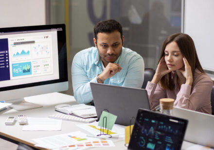 A diverse team of AWS infrastructure experts reviewing a scalable cloud architecture diagram on a large screen, with AWS service icons and upward growth arrows.