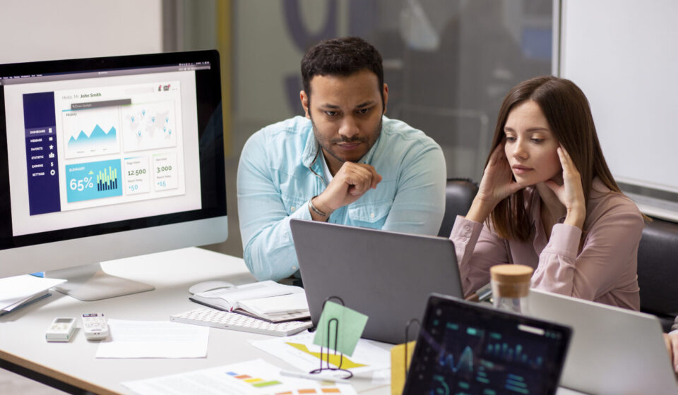A diverse team of AWS infrastructure experts reviewing a scalable cloud architecture diagram on a large screen, with AWS service icons and upward growth arrows.