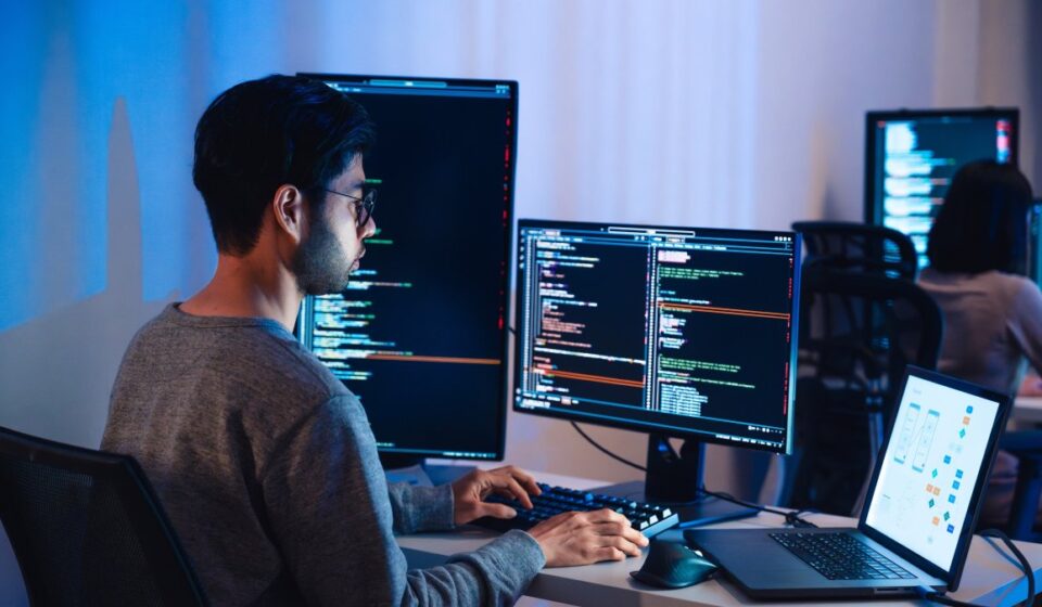 A team of software engineers collaborating around a glowing Golang Gopher mascot on a large monitor, showcasing Golang Backend architecture diagrams, server racks, and high-speed data pathways in a modern, high-tech office environment.
