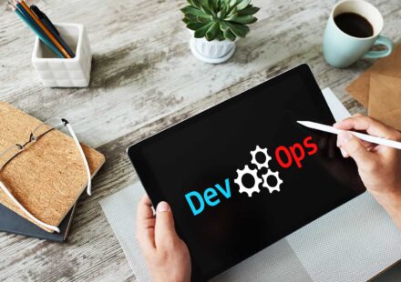 A thought-provoking illustration featuring a magnifying glass searching through a vast labyrinth of interconnected gears, code snippets, and cloud icons, symbolizing the complexity of the hiring landscape. A glowing "Help Wanted" sign flickers in the background, while the overlaid text reads "Why DevOps Talent Is Hard to Find."